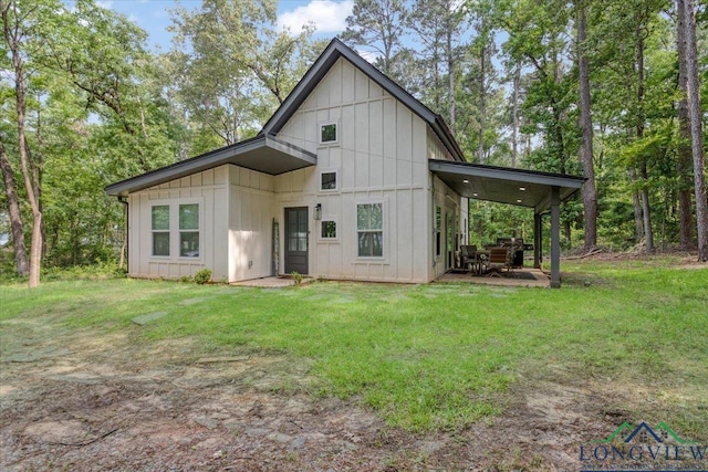 299 Southshore Dr, Lone Star, TX 75668 - rear view of house featuring board and batten siding, a patio area, and a lawn