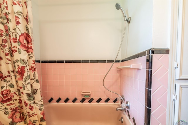 bathroom featuring shower / bathtub combination with curtain and tile walls