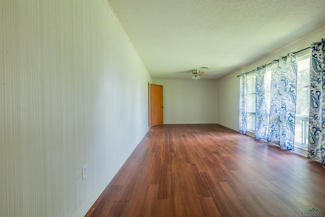 empty room featuring ceiling fan, dark hardwood / wood-style floors, and a textured ceiling