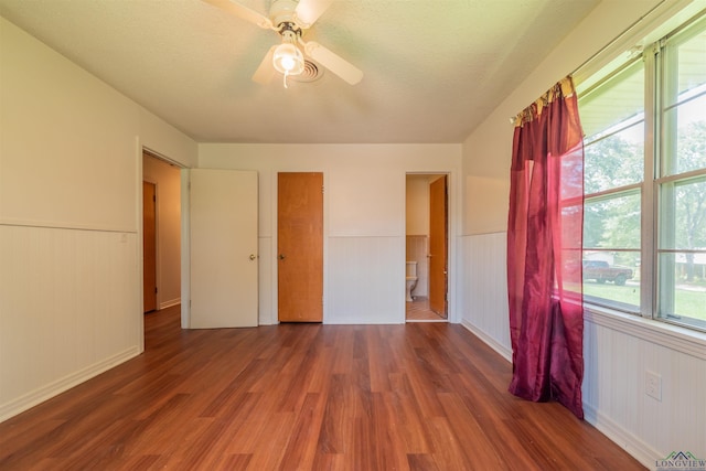 unfurnished bedroom featuring ceiling fan, dark hardwood / wood-style floors, and ensuite bathroom