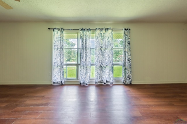 unfurnished room featuring dark hardwood / wood-style flooring and a textured ceiling