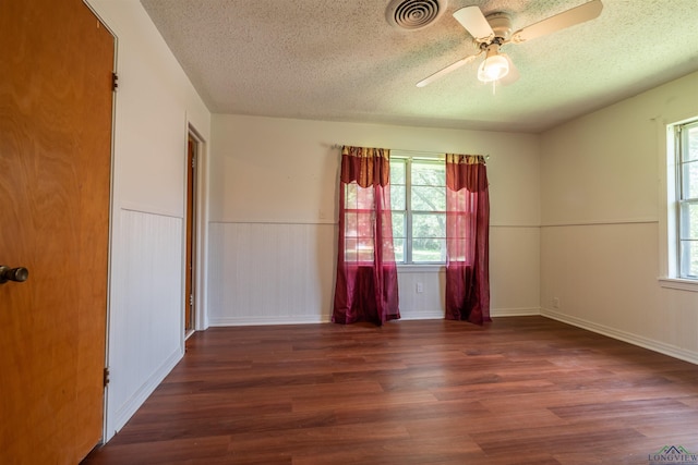 empty room featuring a textured ceiling, ceiling fan, and dark hardwood / wood-style floors