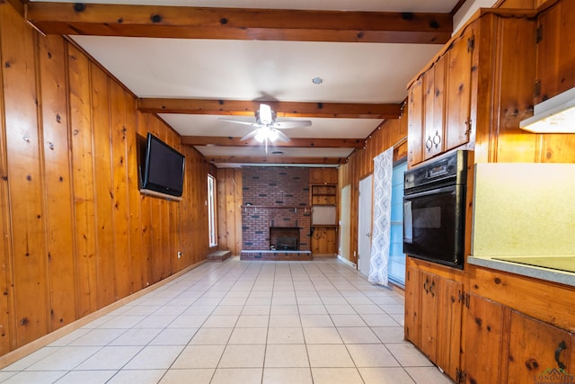 unfurnished living room with wood walls, beamed ceiling, and light tile patterned flooring