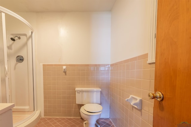 bathroom featuring tile patterned floors, toilet, tile walls, and walk in shower