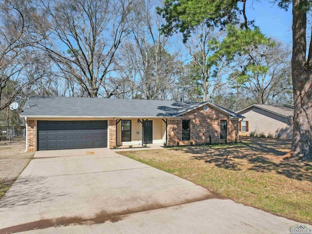 view of front of house with driveway, a front yard, a garage, and brick siding