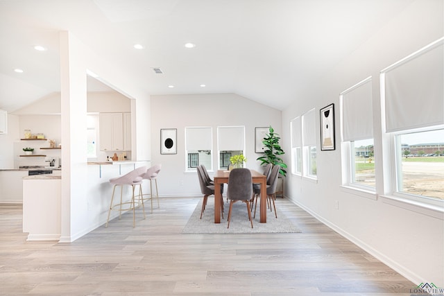 dining room featuring lofted ceiling and light wood-type flooring