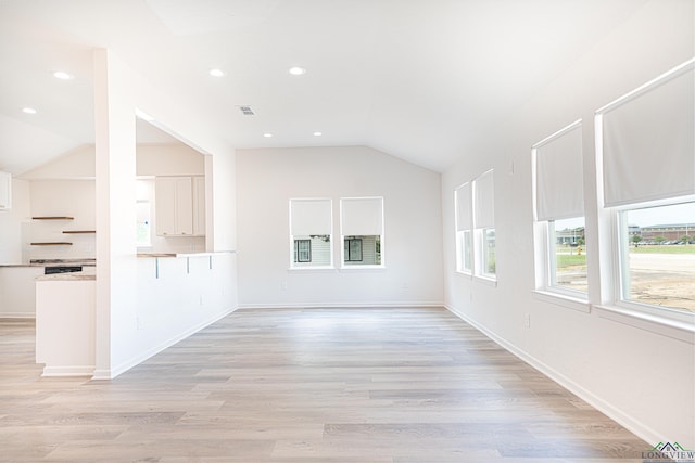 unfurnished living room with light hardwood / wood-style floors and vaulted ceiling