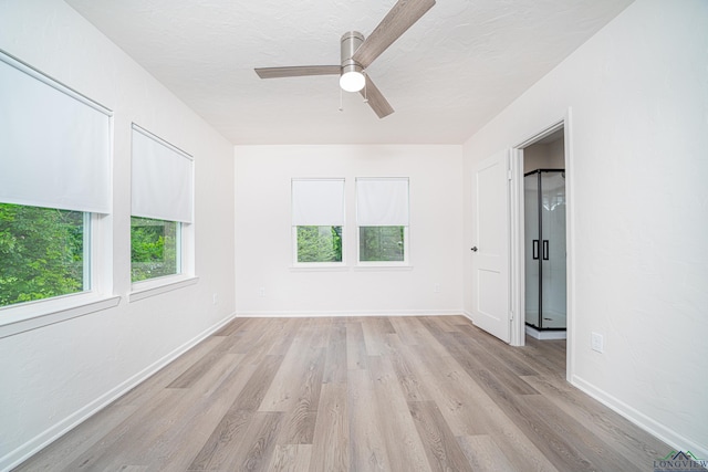 spare room with a textured ceiling, light wood-type flooring, and ceiling fan