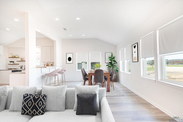 living room featuring light hardwood / wood-style flooring and vaulted ceiling