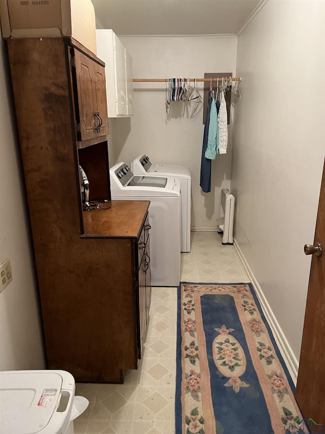 laundry area with cabinets, light tile patterned floors, ornamental molding, and washing machine and dryer