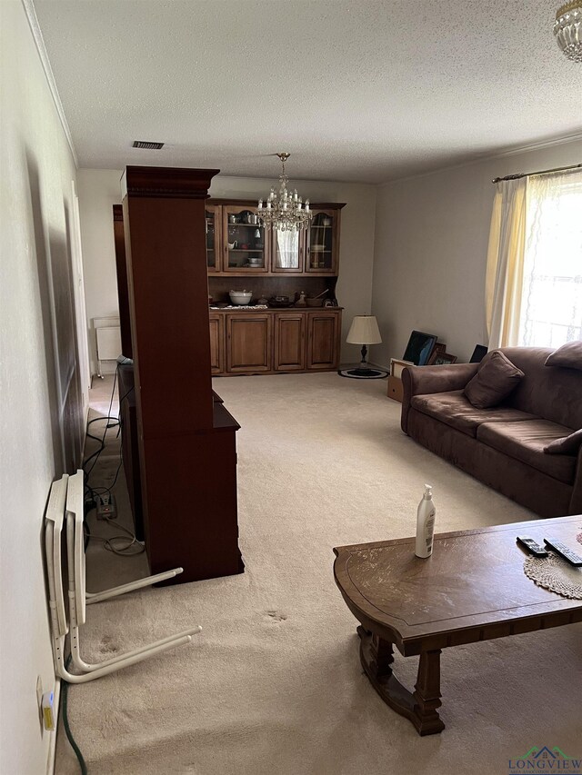 carpeted living room with a textured ceiling and a chandelier