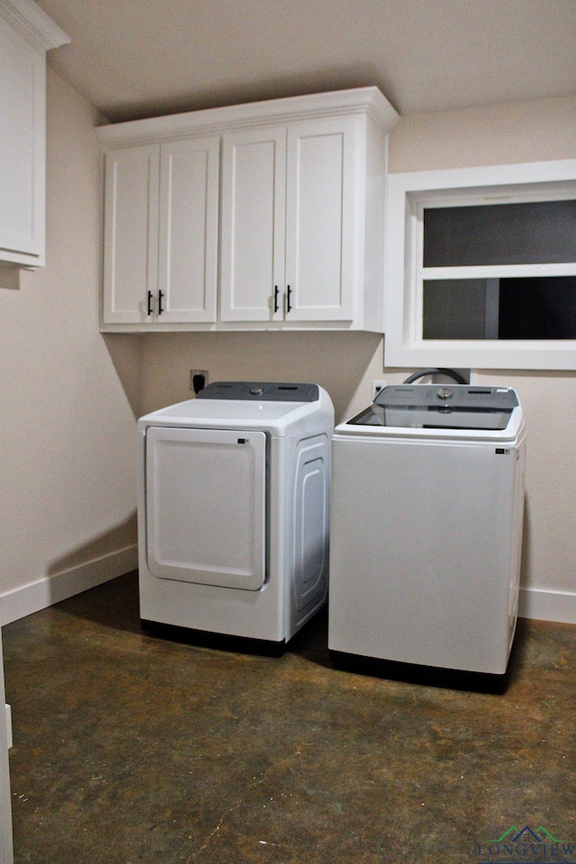 laundry room with separate washer and dryer and cabinets