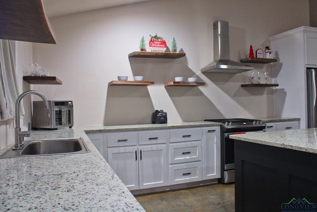 kitchen featuring stainless steel appliances, white cabinetry, sink, and wall chimney range hood