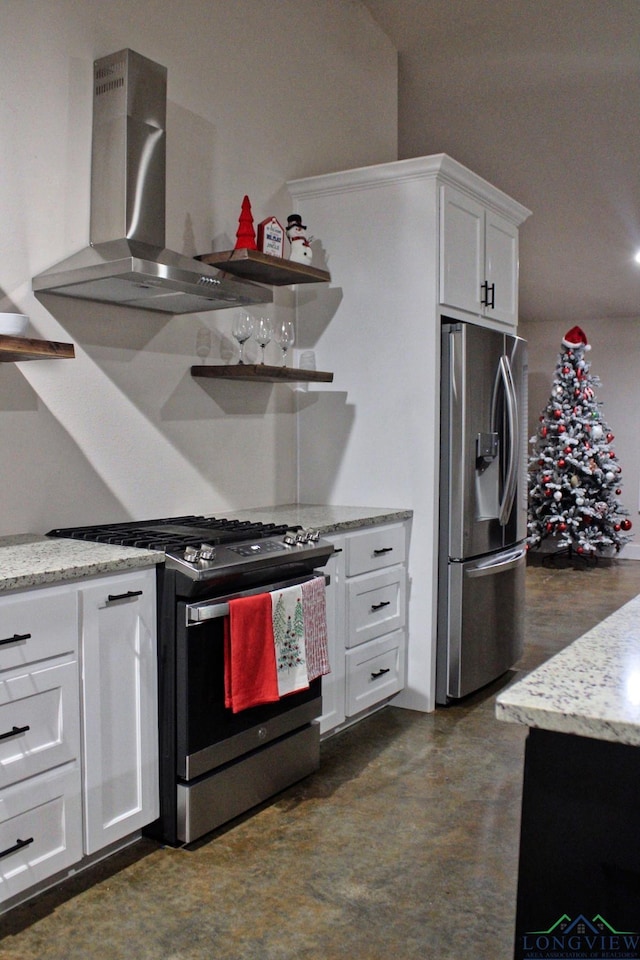 kitchen with stainless steel appliances, light stone countertops, wall chimney range hood, and white cabinets