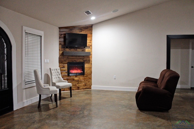 sitting room with concrete floors and a fireplace