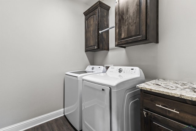 laundry area featuring baseboards, cabinet space, dark wood-type flooring, and independent washer and dryer