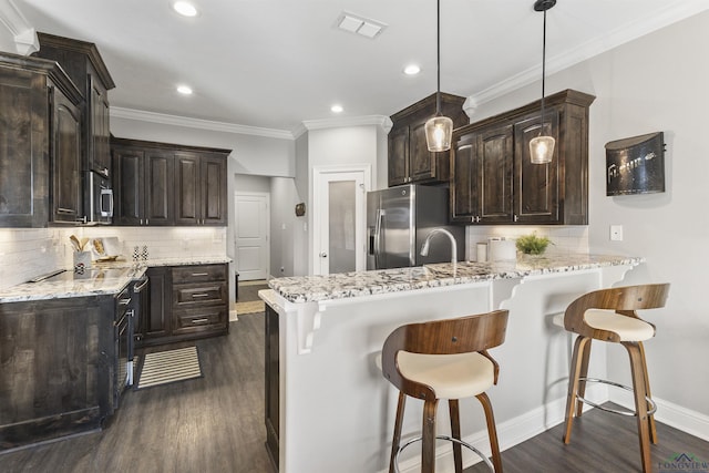 kitchen featuring a peninsula, visible vents, dark brown cabinetry, and stainless steel appliances