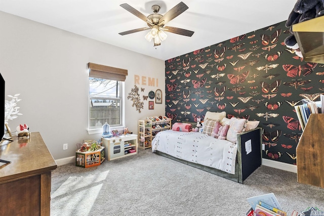 carpeted bedroom featuring baseboards, ceiling fan, an accent wall, and wallpapered walls