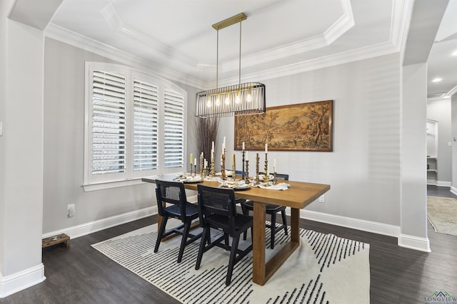 dining room featuring crown molding, wood finished floors, baseboards, and a raised ceiling