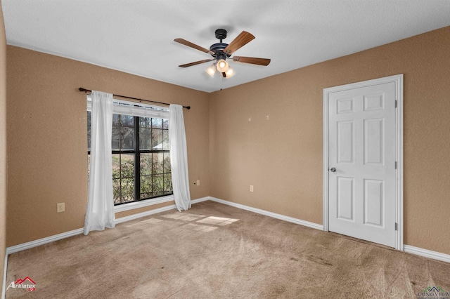 unfurnished bedroom featuring carpet floors, a ceiling fan, and baseboards