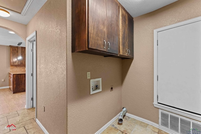 laundry room with cabinet space, stone tile floors, visible vents, baseboards, and washer hookup