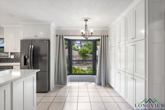 1611 Springdale St, Longview, TX 75604 - kitchen with refrigerator with ice dispenser, a chandelier, white cabinets, tasteful backsplash, and decorative light fixtures