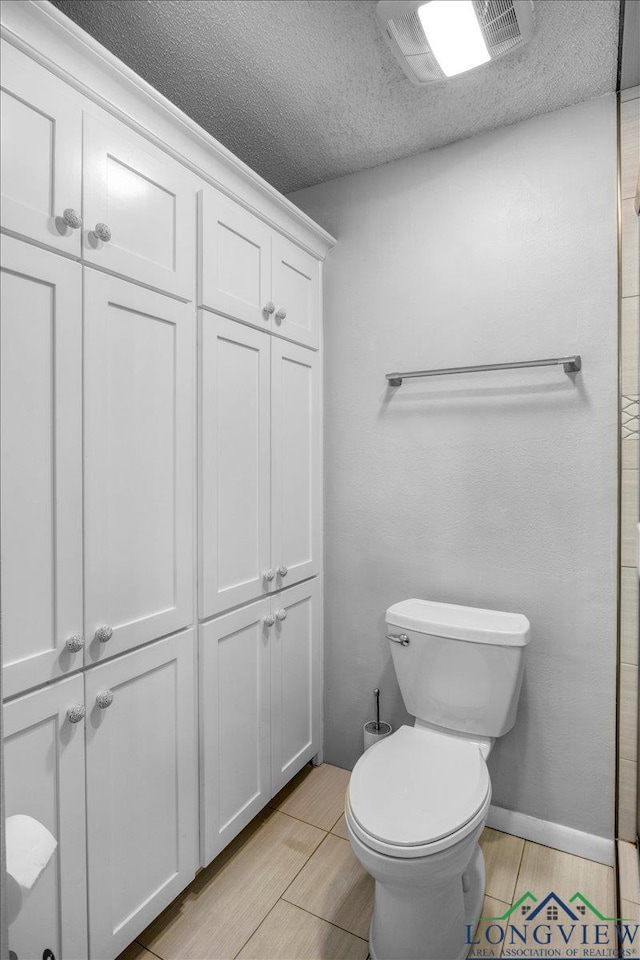1611 Springdale St, Longview, TX 75604 - bathroom featuring toilet, wood finished floors, and a textured ceiling