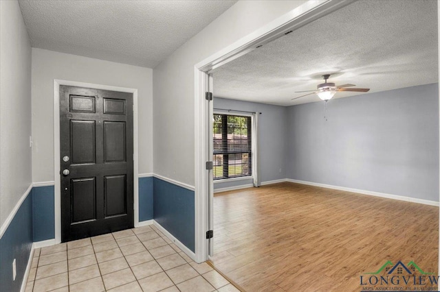 1611 Springdale St, Longview, TX 75604 - entryway with a textured ceiling, ceiling fan, light wood-style flooring, and baseboards