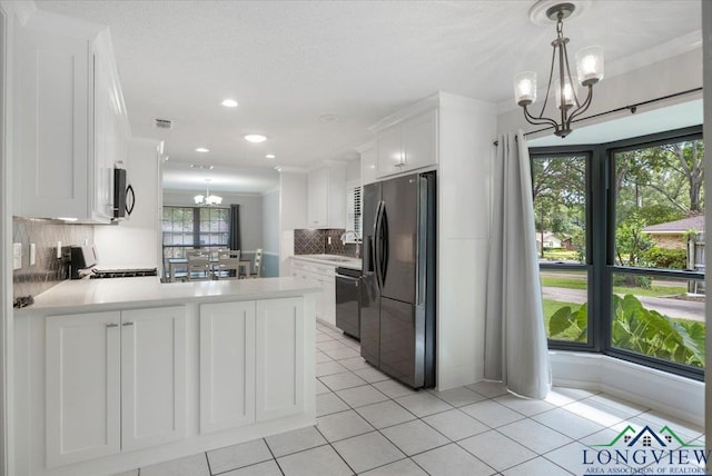 1611 Springdale St, Longview, TX 75604 - kitchen with refrigerator with ice dispenser, a chandelier, stainless steel microwave, black dishwasher, and white cabinets