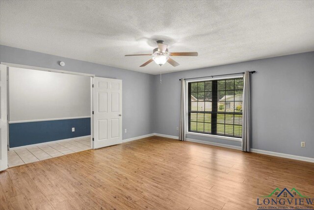 1611 Springdale St, Longview, TX 75604 - spare room featuring ceiling fan, wood finished floors, a textured ceiling, and baseboards