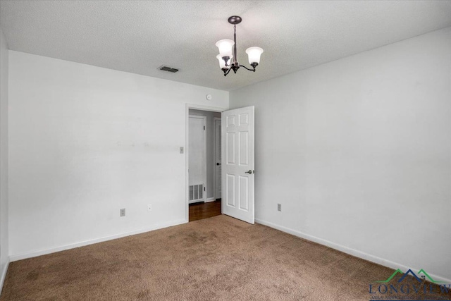 1611 Springdale St, Longview, TX 75604 - carpeted empty room with a chandelier, baseboards, and a textured ceiling