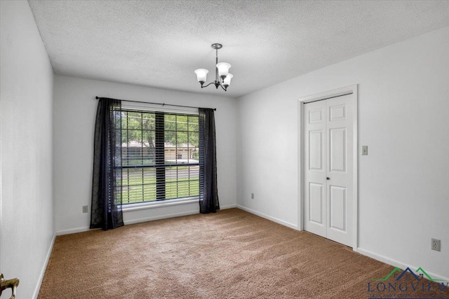 1611 Springdale St, Longview, TX 75604 - carpeted empty room featuring a chandelier, a textured ceiling, and baseboards