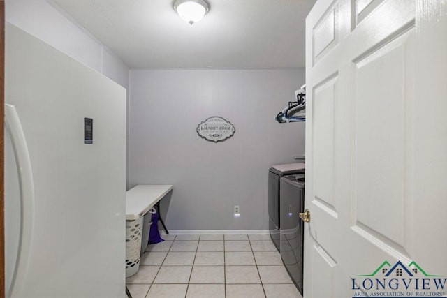 1611 Springdale St, Longview, TX 75604 - laundry area featuring washing machine and dryer, light tile patterned floors, and baseboards
