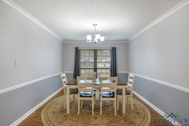 1611 Springdale St, Longview, TX 75604 - dining area with a chandelier, wood finished floors, crown molding, baseboards, and a textured ceiling