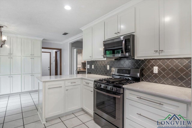1611 Springdale St, Longview, TX 75604 - kitchen with stainless steel appliances, a peninsula, white cabinets, backsplash, and crown molding
