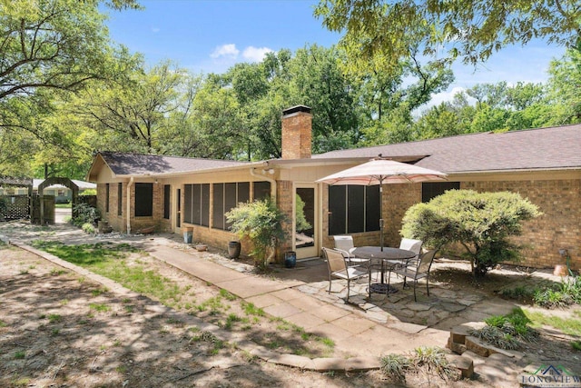 1492 Sleepy Hollow Ln, Canton, TX 75103 - back of property with a chimney, brick siding, a patio area, and a sunroom