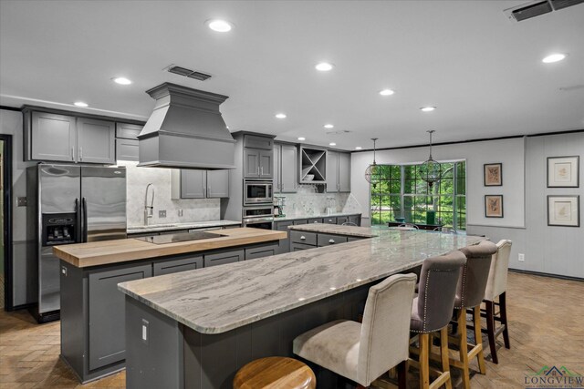 1492 Sleepy Hollow Ln, Canton, TX 75103 - kitchen with a large island, custom exhaust hood, gray cabinets, and appliances with stainless steel finishes