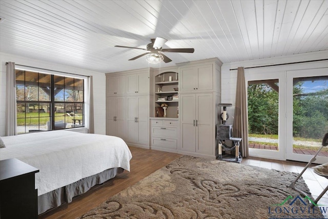 bedroom featuring multiple windows, dark hardwood / wood-style flooring, access to outside, and wooden ceiling