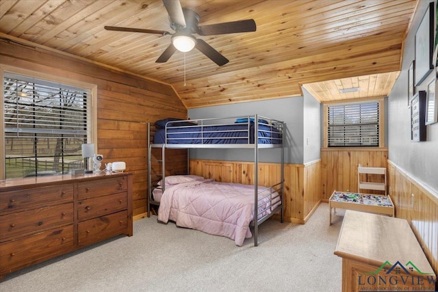 carpeted bedroom with multiple windows, lofted ceiling, wood ceiling, and wood walls