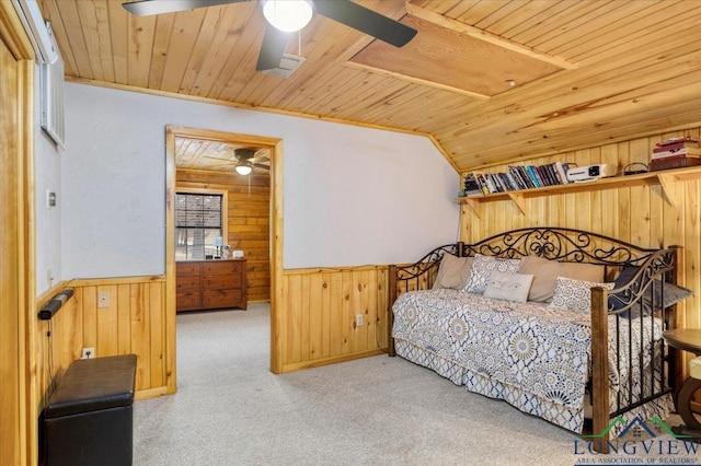 carpeted bedroom with lofted ceiling, wood ceiling, and wooden walls