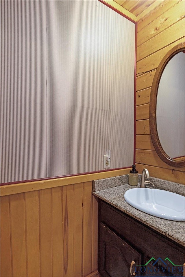 bathroom with vanity and wooden walls