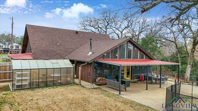 rear view of property featuring an outbuilding, a lawn, and a patio