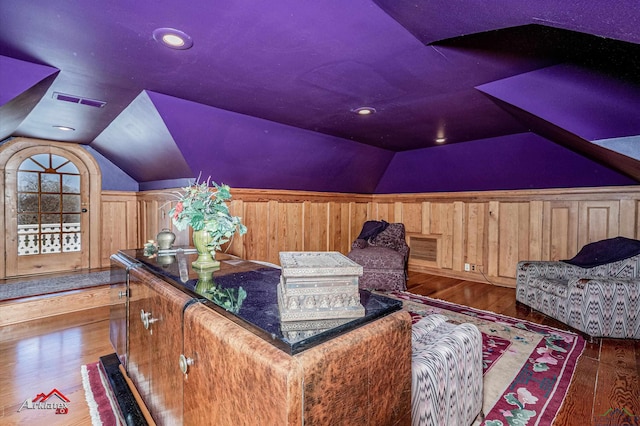 interior space featuring wood walls, dark wood-type flooring, and lofted ceiling