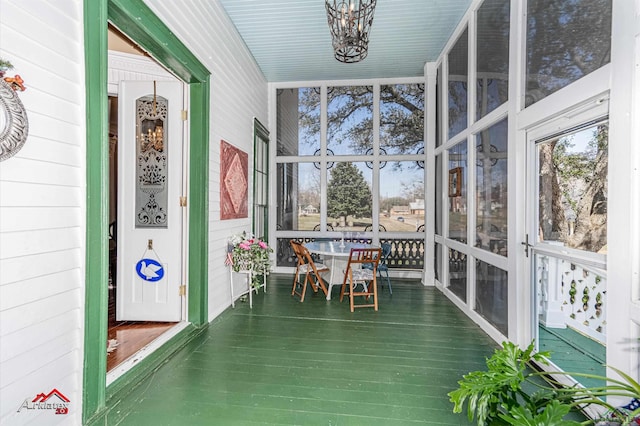 unfurnished sunroom featuring a notable chandelier