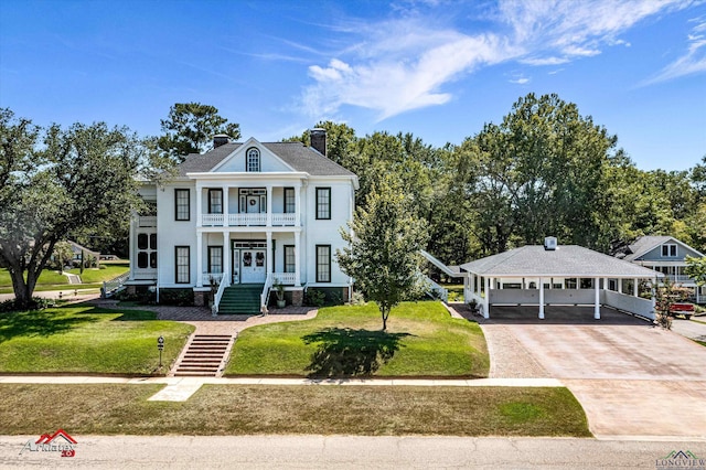 view of front of home with a front lawn, a balcony, and a carport