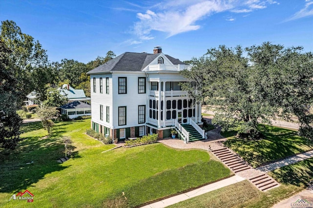 back of house featuring a lawn and a sunroom