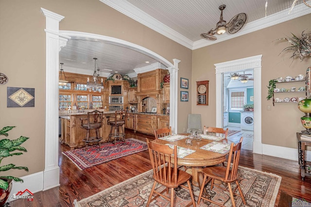 dining room featuring ornate columns, dark hardwood / wood-style flooring, ornamental molding, and washer / dryer