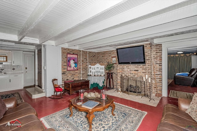 living room featuring beamed ceiling and a brick fireplace