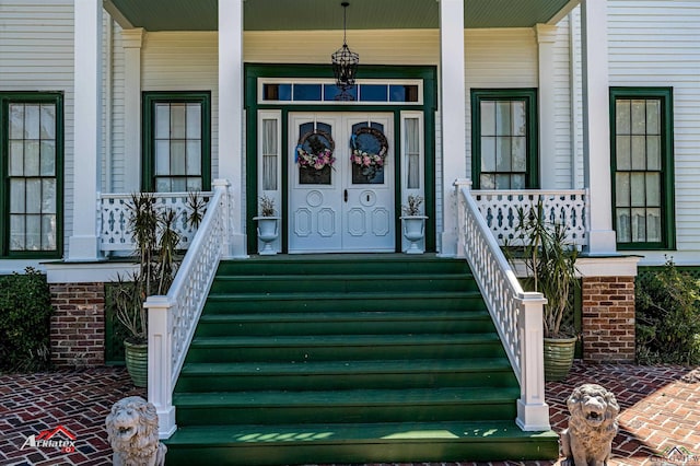 entrance to property featuring a porch and french doors