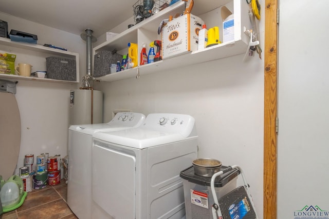 clothes washing area featuring water heater, dark tile patterned floors, and independent washer and dryer